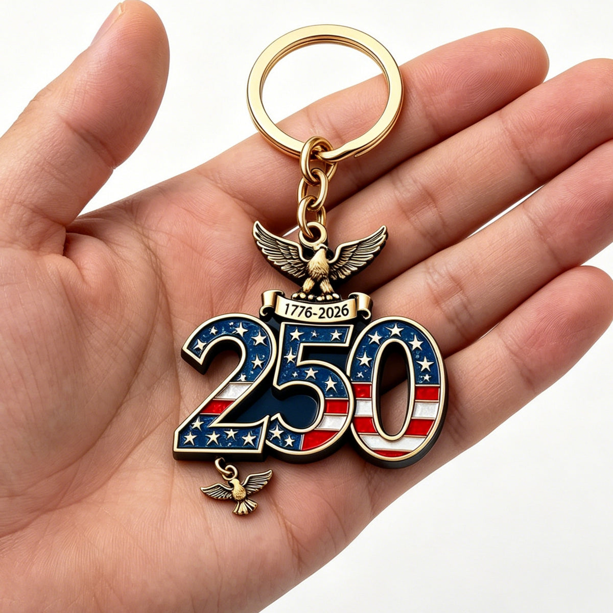 A keychain commemorating the 250th anniversary of the USA, held in a hand and featuring the US flag.